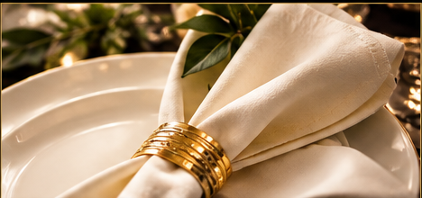 White linen napkin tied with a gold ribbon